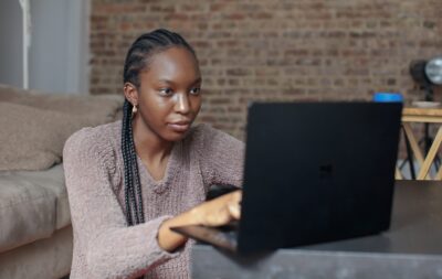 kvinna skriver CV på dator och ska söka jobb