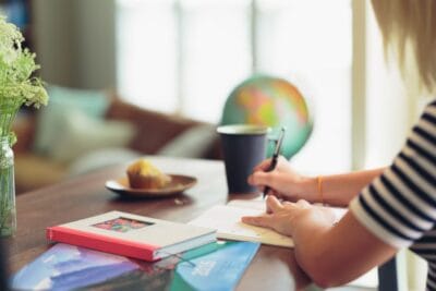 En person som skriver i en skrivbok | NTI-skolan