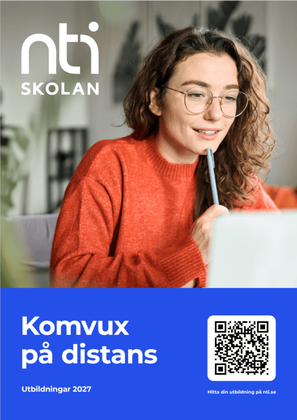 En kvinna i orange tröja sitter vid en laptop.
